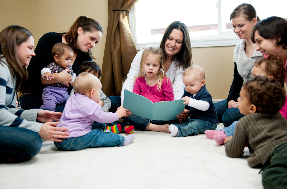 preschoolers and their parents listening to a woman read a story