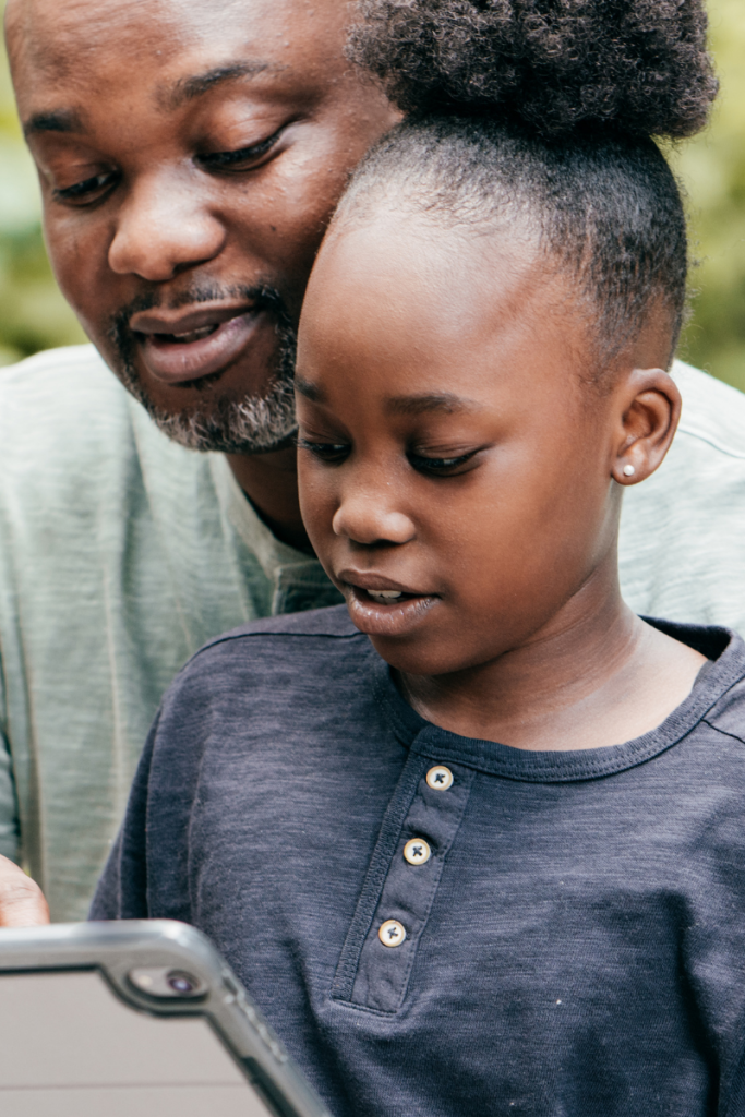 Dad and daughter looking at an ipad together
